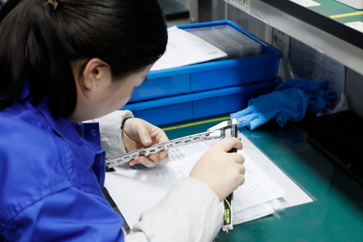 Титановые травматические стопорные пластины и винты с метрологическими инструментами на хирургическом лотке, что свидетельствует о точности производства OEM/ODM.